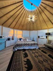 Glamping-Sky Dome Yurt-Tiny House-2 by Lavenders field في Valley Center: غرفة نوم بسرير كبير في خيمة