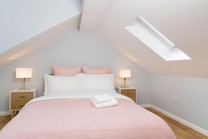 a white bedroom with a bed with a pink blanket at Delphina - Spacious 2BR Modern Maisonette in London