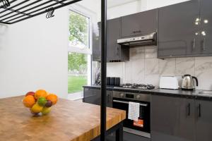 a kitchen with a bowl of fruit on a counter at Delphina - Spacious 2BR Modern Maisonette in London