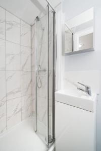 a bathroom with a shower and a sink at Delphina - Spacious 2BR Modern Maisonette in London