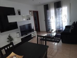 uma sala de estar com um sofá e uma televisão em sweet house close to airport em El Prat de Llobregat