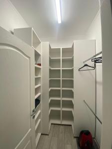 un vestidor con estanterías blancas y una puerta en Apartament Claudia en Baia Mare