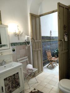 a bathroom with a sink and a toilet and a door at Alojamientos con encanto en casa de patio in Córdoba