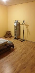 a room with a bed and a towel rack with a teddy bear at Simple family apartment in Liepāja