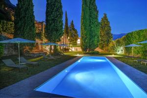 een zwembad in een tuin met parasols bij 5 Terrazze Exlusive Apartments in Gargnano