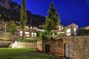 un gran edificio de piedra con patio por la noche en 5 Terrazze Exlusive Apartments, en Gargnano