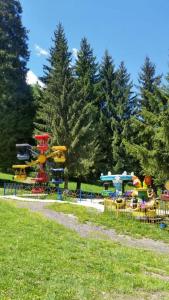 un parque con parque infantil con una montaña rusa en T&M Cottages, en Bakuriani