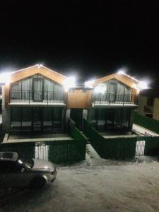 a building with a car parked in front of it at night at T&M Cottages in Bakuriani