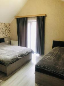 sypialnia z 2 łóżkami i oknem w obiekcie T&M Cottages w mieście Bakuriani