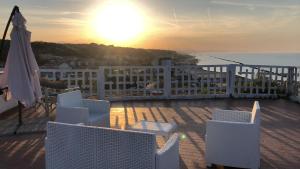 een balkon met stoelen en de zonsondergang boven de oceaan bij Appartamenti "LE CASETTE DI TERESA" in Ortona