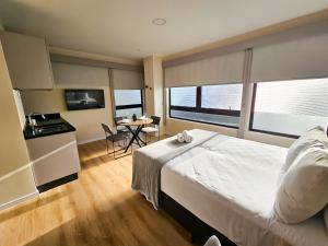 Un dormitorio con una cama grande y una mesa con sillas. en Bewiki en Florianópolis