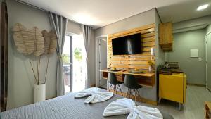 1 dormitorio con 1 cama y escritorio con ordenador en 22- Studio SPA luxo en Curitiba