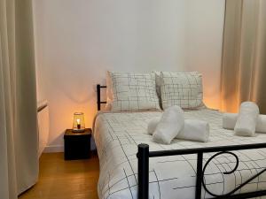 1 dormitorio con 1 cama con sábanas y almohadas blancas en Les Logis d'Esmeralda-Des appartements au charme intemporel, en Romorantin-Lanthenay