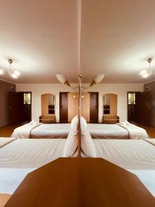 a room with a bunch of white beds at Парк хотел Боили-Кирека in Kaspichan +97 photos