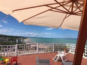 een balkon met een parasol en uitzicht op de oceaan bij Appartamenti "LE CASETTE DI TERESA" in Ortona