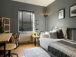 a bedroom with a bed and a table and a desk at Townhouse in trendy suburb of Hoole in Chester