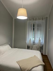 um quarto com uma cama branca e uma janela em Podere il Glicine Wellness Charme & Relax em Fresonara