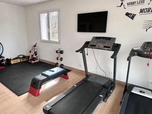 um quarto com um ginásio com uma passadeira e uma televisão de ecrã plano em Podere il Glicine Wellness Charme & Relax em Fresonara