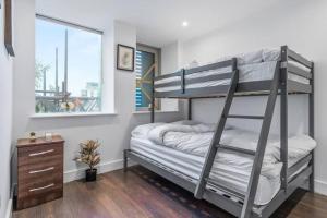 a bunk bed in a room with a ladder at Sleep 7 20 mins from London Waterloo BP8 in London