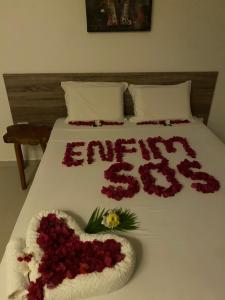 un letto con un cuore fatto di fiori di Pousada Águas de Tamandaré a Tamandaré