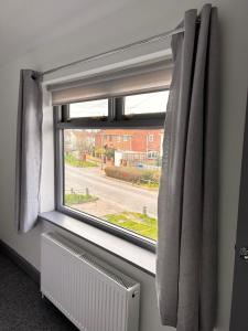 a window with a curtain and a radiator at Apple Yard in Norwich