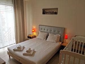 a bedroom with a bed with two towels on it at L Oliveraie - Piscine chauffee in Les Sables-dʼOlonne +23 photos