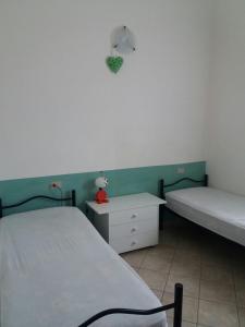 Cette chambre comprend deux lits, une table de nuit et un couvre-lit. dans l'établissement Casa di Nanni, à Villasimius