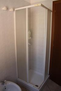 La salle de bains est pourvue d'une douche avec une porte en verre. dans l'établissement Casa di Nanni, à Villasimius