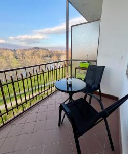 una mesa y sillas en un balcón con vistas en Appartamento alle porte d'Ivrea, en Banchette