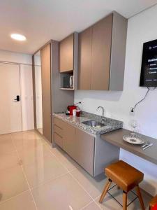 a kitchen with a sink and a counter with a stool at Studio bem localizado / Prox estação Trianon in São Paulo