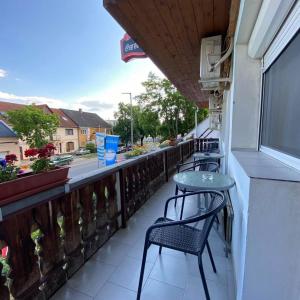 a patio with chairs and a table on a balcony at Lenzl's Panzió in Szigetvár