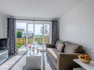 a living room with a couch and a large sliding glass door at 1 Bed in Attleborough 86671 in Caston