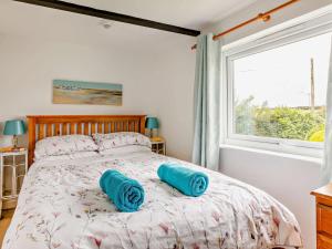 a bedroom with a bed with blue pillows on it at 2 bed in Woolacombe 57907 in West Down