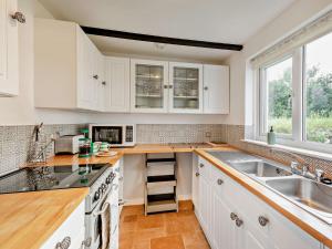 a kitchen with white cabinets and a sink at 2 bed in Woolacombe 57907 in West Down