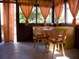 Un comedor con mesa y sillas y ventanas. en King's Residence, en Balestrate