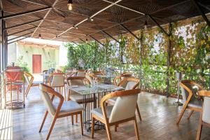 a restaurant with tables and chairs and plants at Seahorse Hotel & Spa in Negombo