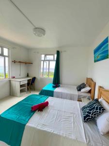 - une chambre avec 2 lits et un bureau dans l'établissement La Residence Emmaüs, à Rodrigues Island