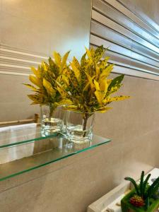 a vase with yellow flowers sitting on a glass table at La Residence Emmaüs in Rodrigues Island