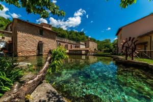 une piscine d'eau en face d'un bâtiment dans l'établissement Rifugio dell'Ulivo near Assisi, à Rivotorto