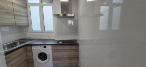 a white kitchen with a washing machine in it at Granada sun in Granada +66 photos