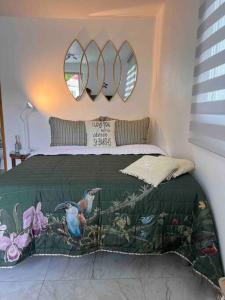 a bedroom with a bed with two birds on it at Maison des Brin - Lorient Camaruche in Saint Barthelemy