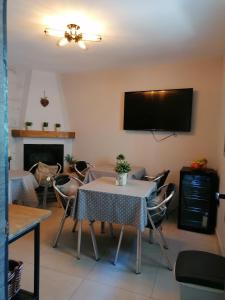 sala de estar con mesa y TV en la pared en Villa Otivar, en Otívar