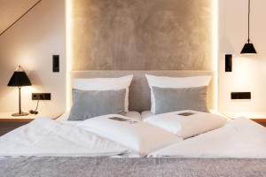 Schlafzimmer mit einem Bett mit weißer Bettwäsche und Kissen in der Unterkunft Flair Hotel Werbetal in Waldeck
