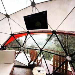 einen Blick aus dem Inneren eines Zeltes mit Stühlen und einem Bildschirm in der Unterkunft Finca Montmagica in Floridablanca
