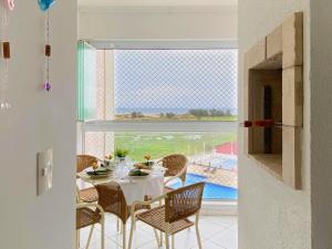 comedor con mesa y sillas y ventana grande en Resid. Clube Mar Grosso - Laguna, en Laguna