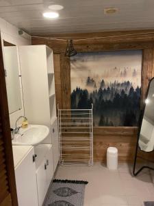 a bathroom with a sink and a painting on the wall at Chalet 9 personnes, piscine, terrasse in Saint-Maurice-sur-Moselle