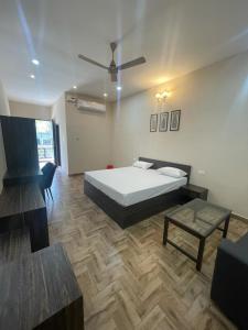 a bedroom with a bed and a table and a couch at VISTARA COURTYARD in Varanasi