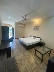 um quarto com uma cama e uma mesa em VISTARA COURTYARD em Varanasi