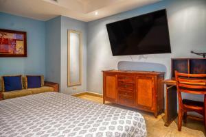 Un dormitorio con una cama y un televisor de pantalla plana. en Bahía Encantada G1, en Jacó