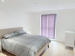 a white bedroom with a bed and a window at Luxury Modern Flat Near Center in London